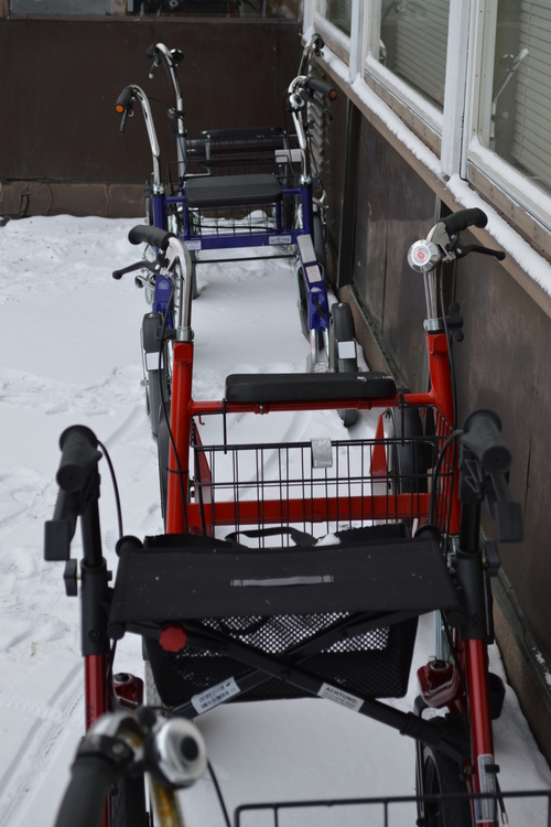Rollaattorit seurakuntatalon seinustalla.