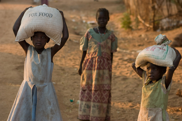 Sudanilaiset tytöt kantavat viljasäkkejä